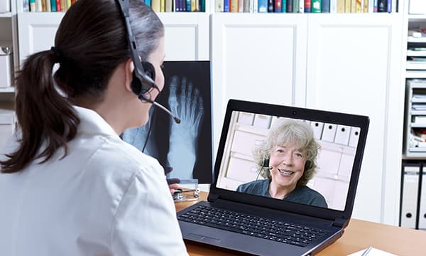 A doctor speaks with a patient during a telehealth appointment. A doctor speaks with a patient during a telehealth appointment.